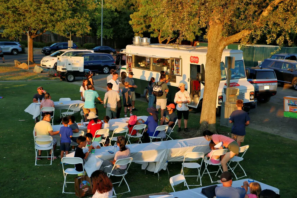 Davis neighbors gathered around food trucks at a Chamber event in the evening