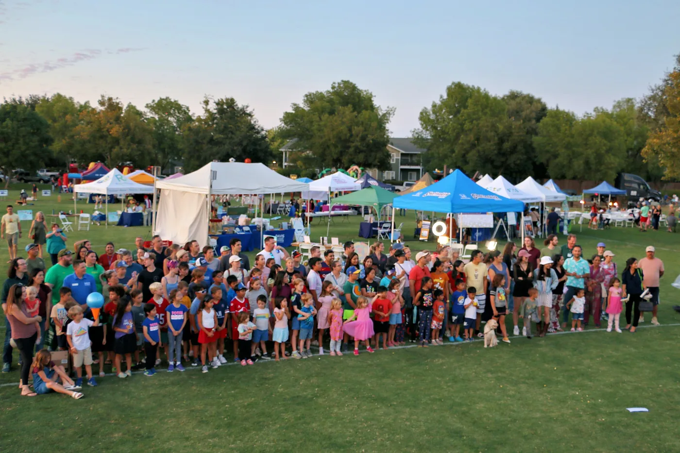 A golden-hour group photo of Davis Chamber members and families gathered together